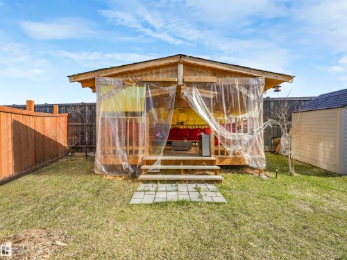 Elevated wood-decked gazebo with steps and a shingle roof, featuring clear protective coverings - 17171 38 Street, Edmonton, AB 