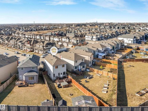 Rear exterior of the property featuring a wooden deck, a fenced yard, and garden beds - 17171 38 Street, Edmonton, AB 