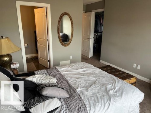 Bedroom featuring neutral wall paint, white trim, and light-colored carpet - 138 Reed Place, Leduc, AB 