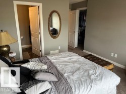 Bedroom featuring neutral wall paint, white trim, and light-colored carpet - 