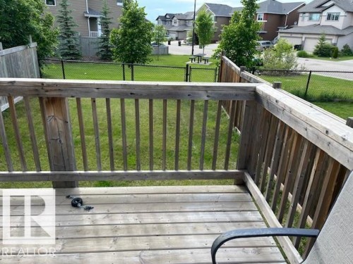 Wood deck with railing overlooking a green space - 138 Reed Place, Leduc, AB 
