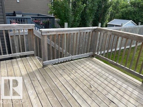 Wood deck featuring a perimeter railing and integrated steps - 138 Reed Place, Leduc, AB 