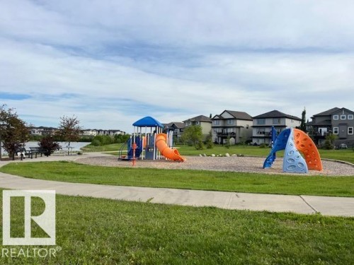 Community playground featuring a multi-level play structure with slides and climbing elements - 138 Reed Place, Leduc, AB 