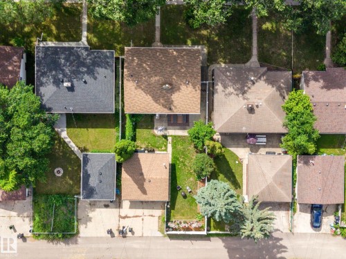 Aerial perspective showcasing a residential property with a brown shingle roof, a detached garage with a brown shingle roof, and a paved driveway - 12115 53 Street, Edmonton, AB 