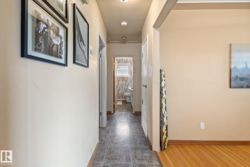 Hallway featuring light-toned walls, tile flooring, and a recessed light fixture - 12115 53 Street, Edmonton, AB 
