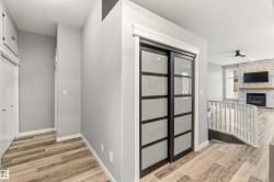 Frosted glass sliding doors with dark framing, wood-finish flooring, and light gray walls - 