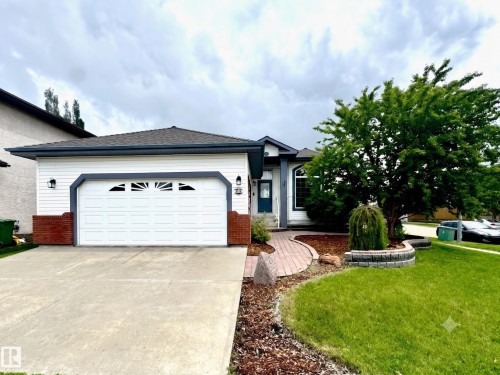 Single-story residence featuring white siding and dark trim accents - 29 Rue Bouchard, Beaumont, AB 