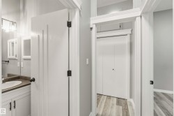 Hallway featuring light wood-finish flooring and neutral wall tones - 