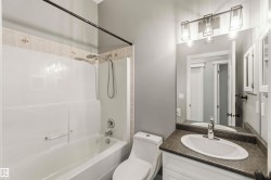 Bathroom featuring a white tub and shower combination with a decorative tile surround - 