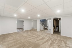 Expansive carpeted area with recessed lighting, drop ceiling, and neutral wall tones - 