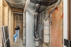 Utility area featuring a water softener system and central vacuum unit - 