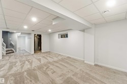 Spacious lower-level room featuring patterned carpeting, recessed lighting, and a drop ceiling - 