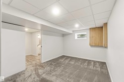 Finished room featuring new carpeting, recessed lighting, drop ceiling, and a built-in wood-finish cabinet - 