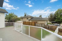 Private deck featuring composite flooring, white aluminum railings, and frosted glass panels - 