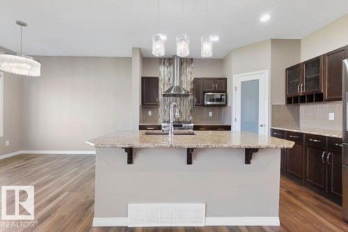 Central kitchen island with a granite countertop and integrated sink - 1306 32A Street, Edmonton, AB 