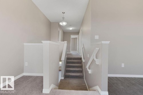 Carpeted staircase with white handrails and balusters - 1306 32A Street, Edmonton, AB 