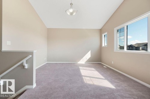 Carpeted room with vaulted ceilings and a semi-flush mount ceiling light - 1306 32A Street, Edmonton, AB 
