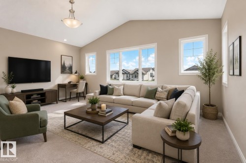 Spacious common area featuring a vaulted ceiling with an overhead light fixture, light-toned carpeting, and multiple windows providing ambient illumination - 1306 32A Street, Edmonton, AB 