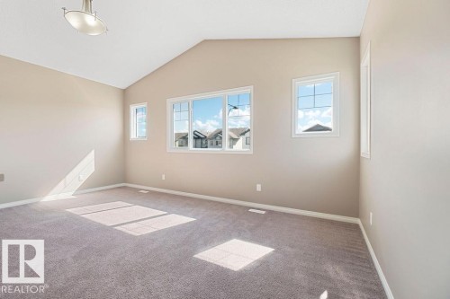 Vaulted ceiling room featuring light neutral wall paint and plush carpeting - 1306 32A Street, Edmonton, AB 