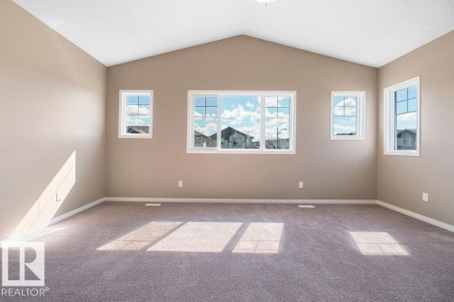 Interior room featuring vaulted ceilings, neutral-toned walls, and plush carpeting - 1306 32A Street, Edmonton, AB 