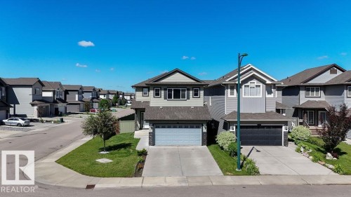 Contemporary two-story residence featuring a light gray exterior with dark trim and a two-car attached garage - 1306 32A Street, Edmonton, AB 