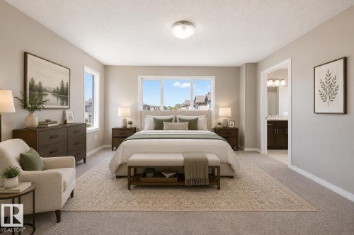 Spacious bedroom featuring light neutral wall paint, carpet flooring, a large window array, and an open doorway to a bathroom with a vanity and triple light fixture - 1306 32A Street, Edmonton, AB 