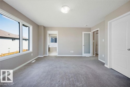 Spacious room featuring neutral carpeting and light-toned walls - 1306 32A Street, Edmonton, AB 