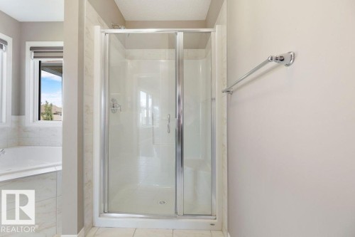Enclosed glass shower stall with chrome hardware, featuring a coordinating towel bar - 1306 32A Street, Edmonton, AB 