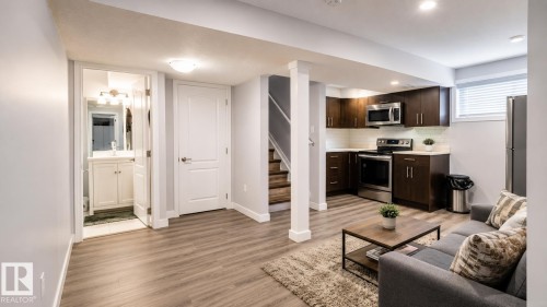 Open-concept living space featuring wood-finish flooring and recessed lighting - 1306 32A Street, Edmonton, AB 