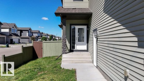 Light-toned siding exterior featuring a covered entry - 1306 32A Street, Edmonton, AB 