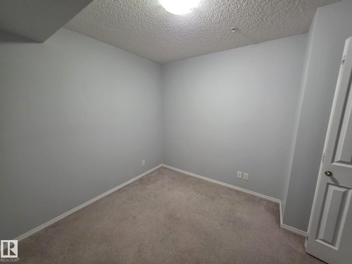 Neutral-toned carpeting paired with light gray walls and white trim - 310 12045 22 Avenue, Edmonton, AB 
