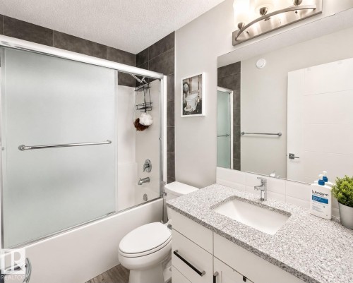 Modern bathroom featuring a white vanity with a speckled countertop and an integrated sink - 2534 Wonnacott Loop, Edmonton, AB 