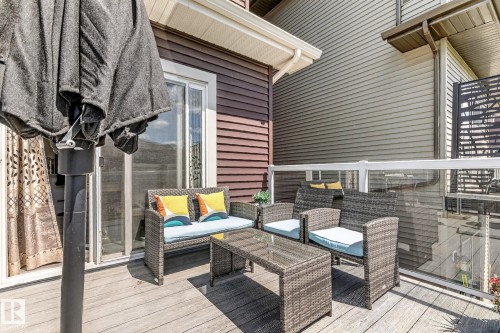Deck featuring wood-finish flooring, glass panel railings, and a sliding glass door entry - 2534 Wonnacott Loop, Edmonton, AB 