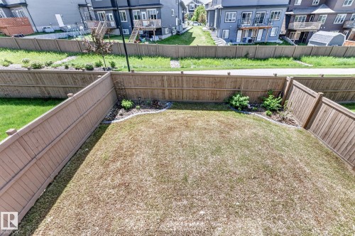 Expansive fenced backyard featuring a level lawn and perimeter landscaping beds - 2534 Wonnacott Loop, Edmonton, AB 