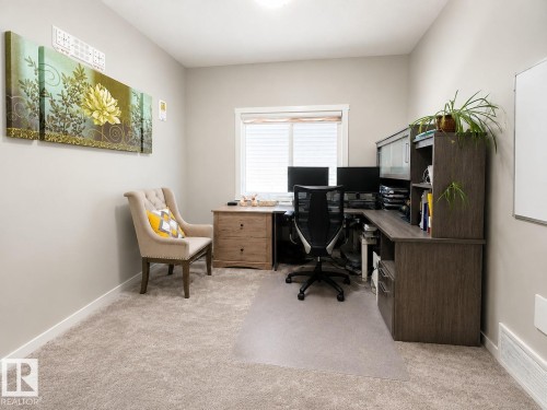 Neutral wall paint with white trim, soft carpet flooring, and a large window with blinds - 2534 Wonnacott Loop, Edmonton, AB 
