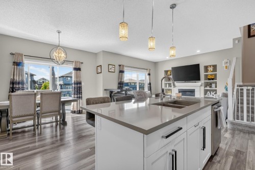 Spacious kitchen island featuring a double-basin sink, high-arc faucet, and light-toned countertop - 2534 Wonnacott Loop, Edmonton, AB 