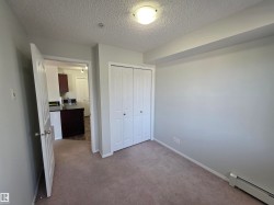 Bedroom featuring light gray walls, textured ceiling, and neutral carpet flooring - 