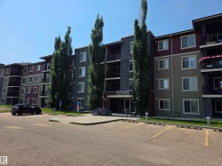 Multi-story residential building featuring a stone facade and contrasting siding - 