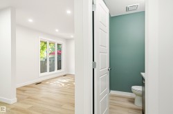 Bright interior space with wood-finish flooring, recessed lighting, and a large multi-pane window - 