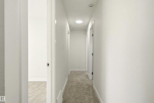Interior hallway featuring light-toned carpeting, white walls, and recessed lighting - 18217 84 Avenue Nw, Edmonton, AB 