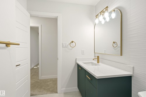Vanity featuring a quartz countertop, integrated rectangular sink, and gold-finish faucet - 18217 84 Avenue Nw, Edmonton, AB 