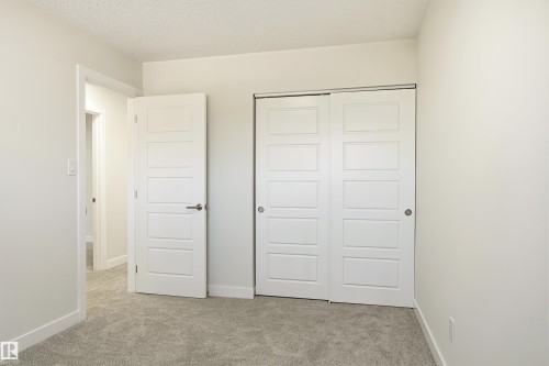 Neutral-toned carpeting complements the white walls and trim - 18217 84 Avenue Nw, Edmonton, AB 