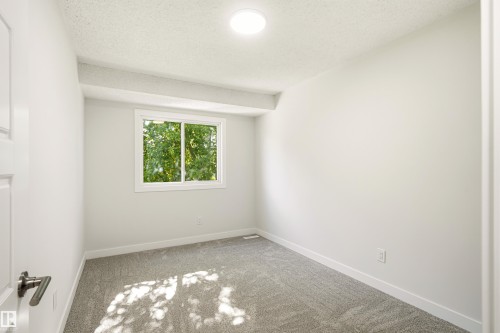 Room featuring light gray carpet, white walls, and a recessed ceiling light - 18217 84 Avenue Nw, Edmonton, AB 
