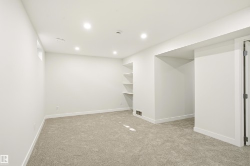 Spacious room with light neutral carpeting and bright white walls - 18217 84 Avenue Nw, Edmonton, AB 