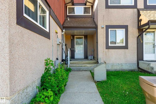 Stucco exterior with brown trim accents, concrete walkway, and covered entryway - 18217 84 Avenue Nw, Edmonton, AB 