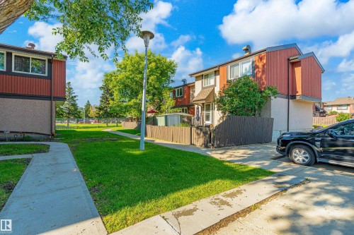 Townhouse exterior featuring a multi-tone facade with red siding and light-colored stucco - 18217 84 Avenue Nw, Edmonton, AB 