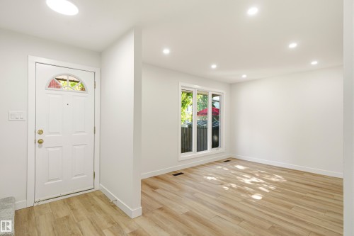 Entryway with a white paneled door featuring an arched glass insert - 18217 84 Avenue Nw, Edmonton, AB 