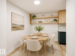 Dining area featuring wood-finish flooring, two tiers of built-in open shelving, light wood cabinetry, and a subway tile backsplash - 