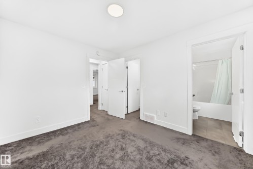 Interior room featuring dark patterned carpeting and bright white walls - 17 4137 76 Street, Edmonton, AB 