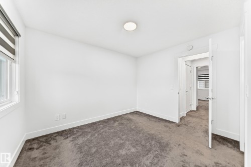 Room featuring white walls, gray carpet, and a window with blinds - 17 4137 76 Street, Edmonton, AB 